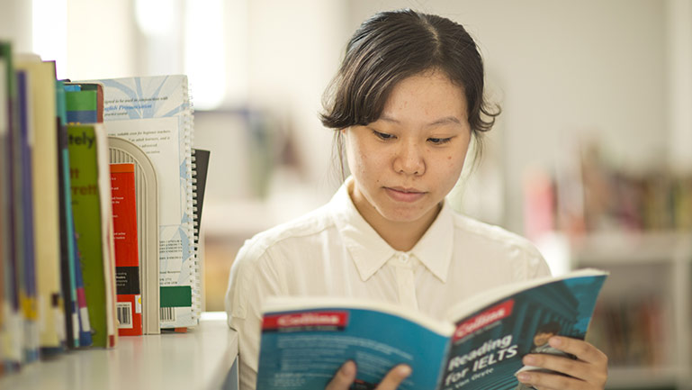 A woman studying for the IELTS exam