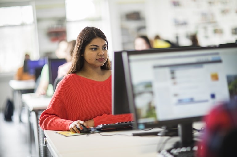 Woman focused, learning vocabulary for IELTS Speaking on her computer