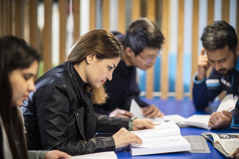 Group of students collaborating on a project in a study room